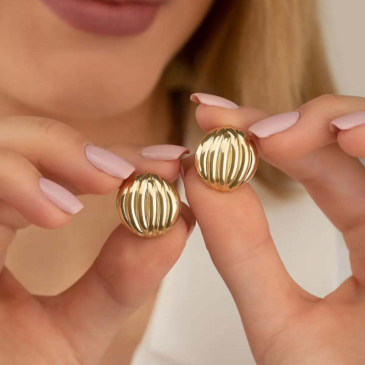 Gold textured ball earrings with ridged surface design.