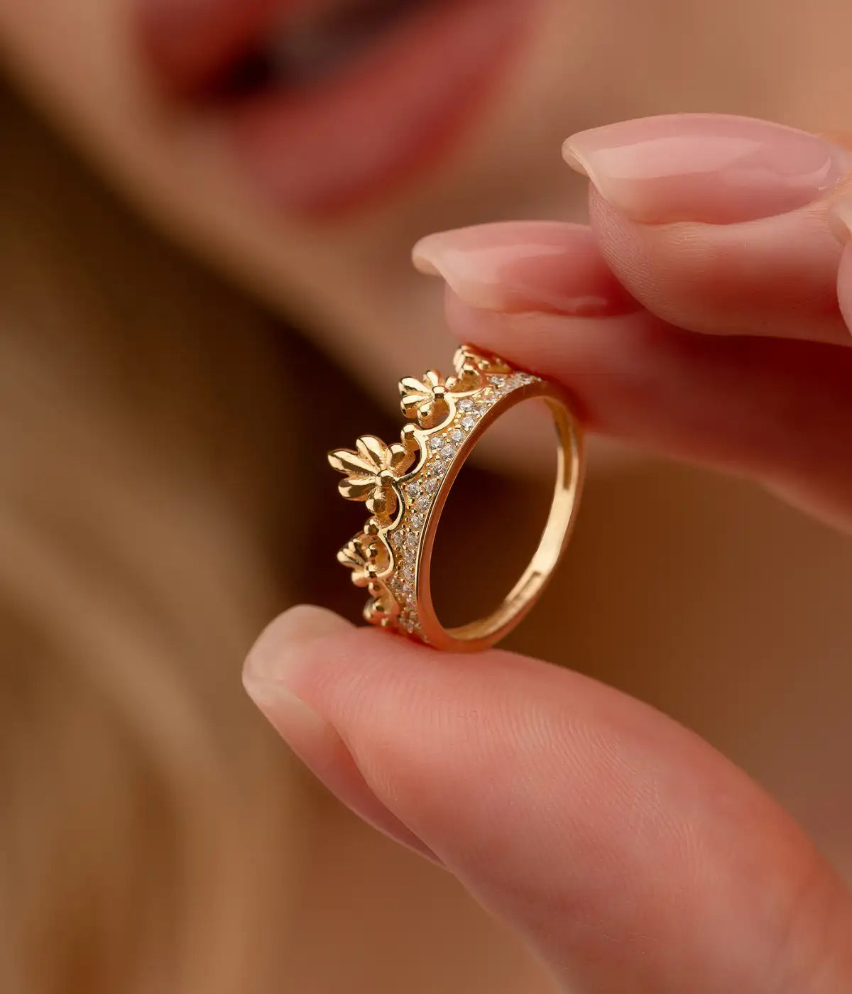 Gold crown ring with intricate diamond-like embellishments.