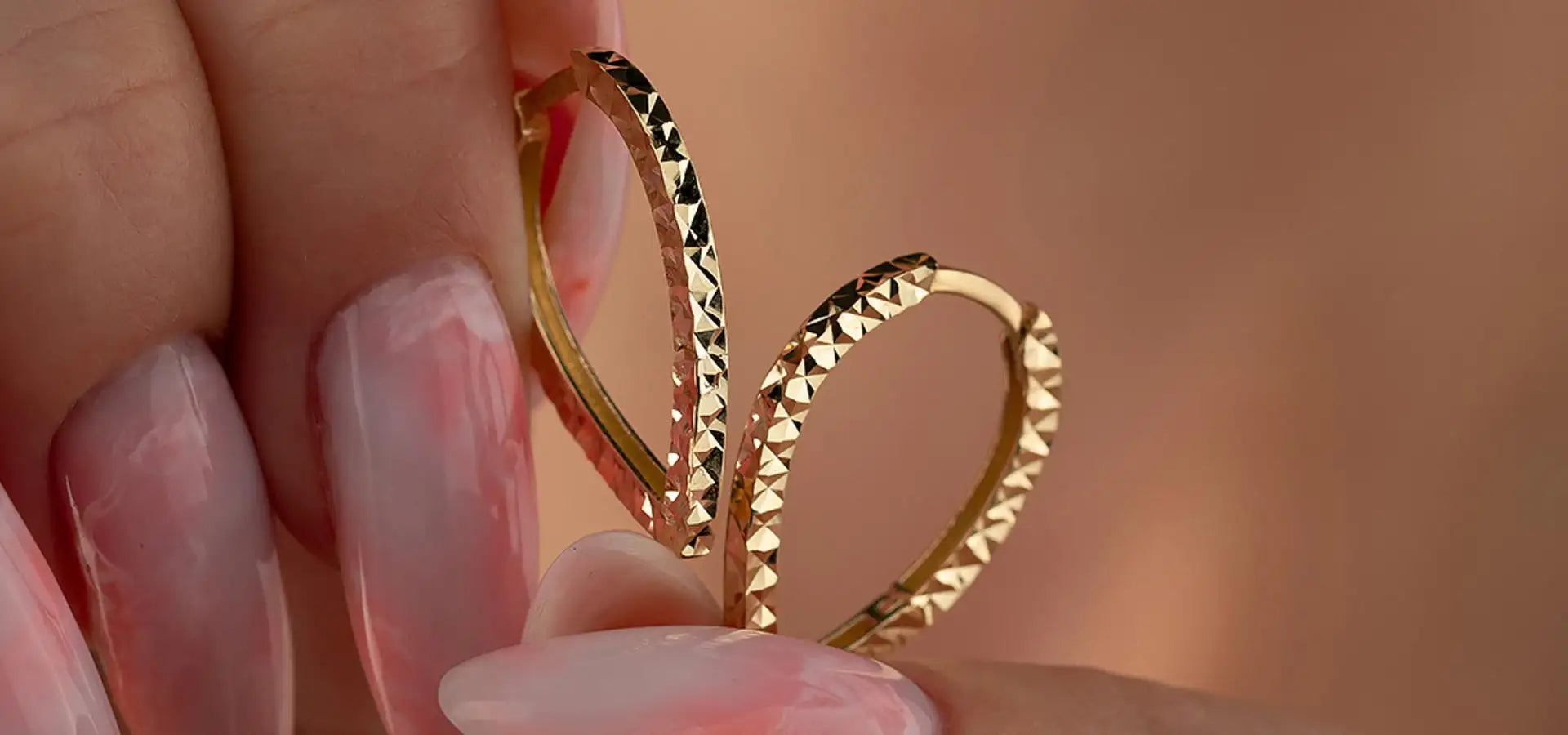 Gold heart-shaped hoop earrings with textured surface design.