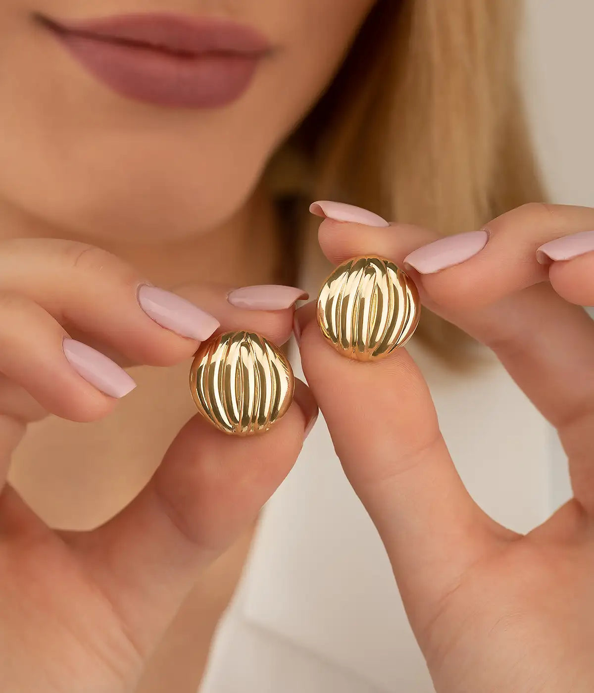 Gold textured ball earrings with ridged surface design.